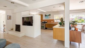 A modern kitchen with white brick walls, a built-in oven, and a large island with a sink. - Charming 2-bedroom Mid-Century Modern house in enchanting Palm Springs (Palm Springs)