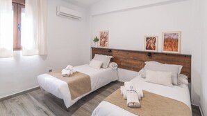A hotel room with two beds, a wooden headboard, and a window with curtains. - El Real de Magiaza Riogordo by Ruralidays (Málaga)