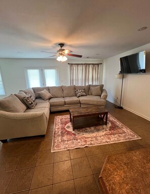 Relax in this cozy living space with a sectional sofa, coffee table, and flat-screen TV.