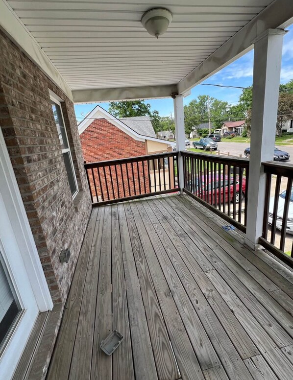 Guests can enjoy a covered porch with a floor and railing, offering an outdoor space.