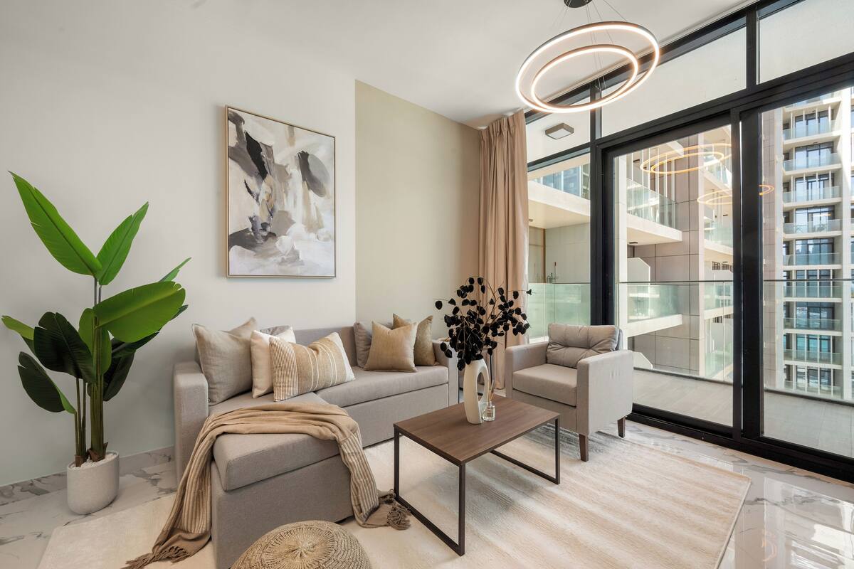 A modern living room with a sofa, coffee table, and potted plants.