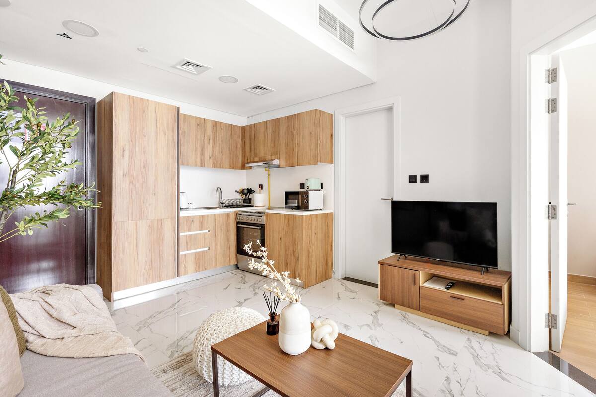 A modern kitchen with wooden cabinets, a built-in oven, and a microwave.