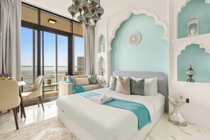 A modern bedroom with a large bed, a view of the city, and a balcony with a dining area. - Silkhaus Al Maryah Vista 1 (Abu Dhabi)