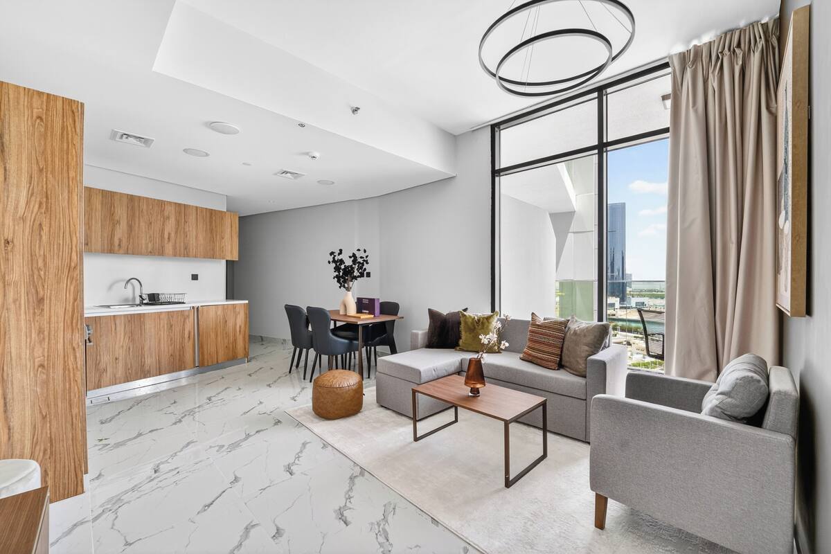 A modern apartment with a kitchen, dining area, and living room.