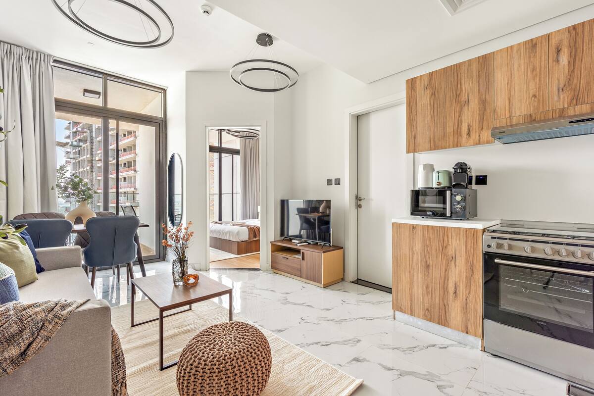 A modern apartment with a living room, dining area, and kitchen.