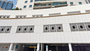 A tall, modern building with a white facade and multiple balconies. - Silkhaus Amaya Towers (Abu Dhabi)