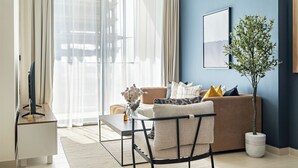 A modern living room with a sofa, a coffee table, and a TV on a stand.