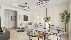 A modern living room with a glass dining table, a grey sofa, and a large potted plant. - Silkhaus Springs 7 (Dubai)