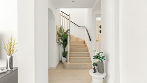 A staircase with a handrail, flanked by potted plants, leading to an upper floor. - Silkhaus Springs 7 (Dubai)
