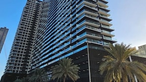 A tall, modern building with a grid-like facade and balconies. - Silkhaus Binghatti Corner (Dubai)