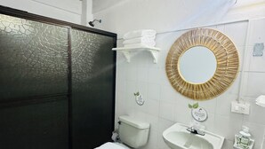 Un bagno con il water, un lavandino e uno specchio.