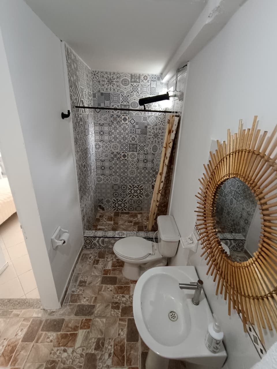 A bathroom with a toilet, sink, and shower area.