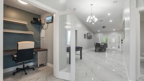 A spacious room with a desk, chair, and a foosball table.