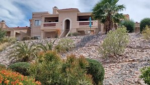 A multi-story building with a flat roof, a central entrance, and a balcony. - Bright, quiet, updated condo in Fountain Hills with mountain views! (Fountain Hills)