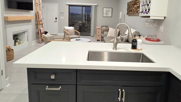 A modern kitchen with dark cabinetry, a white countertop, and a built-in sink. - Bright, quiet, updated condo in Fountain Hills with mountain views! (Fountain Hills)