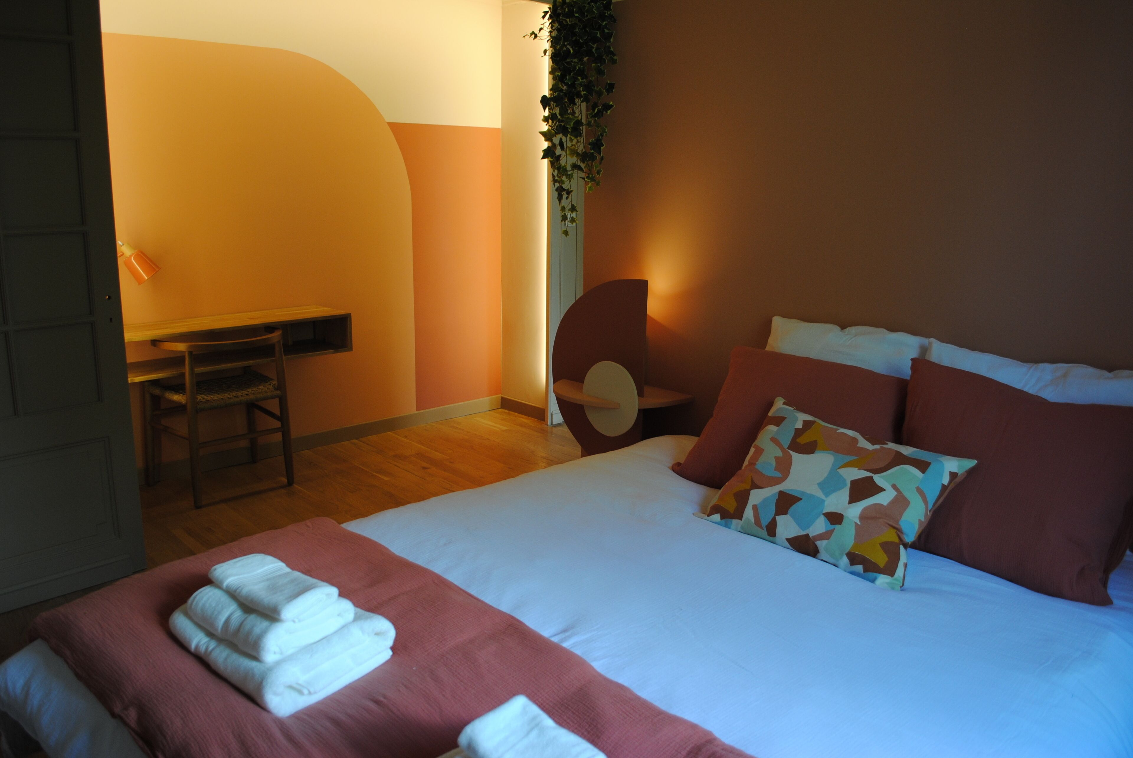 A hotel room with a bed, a desk, and a chair.