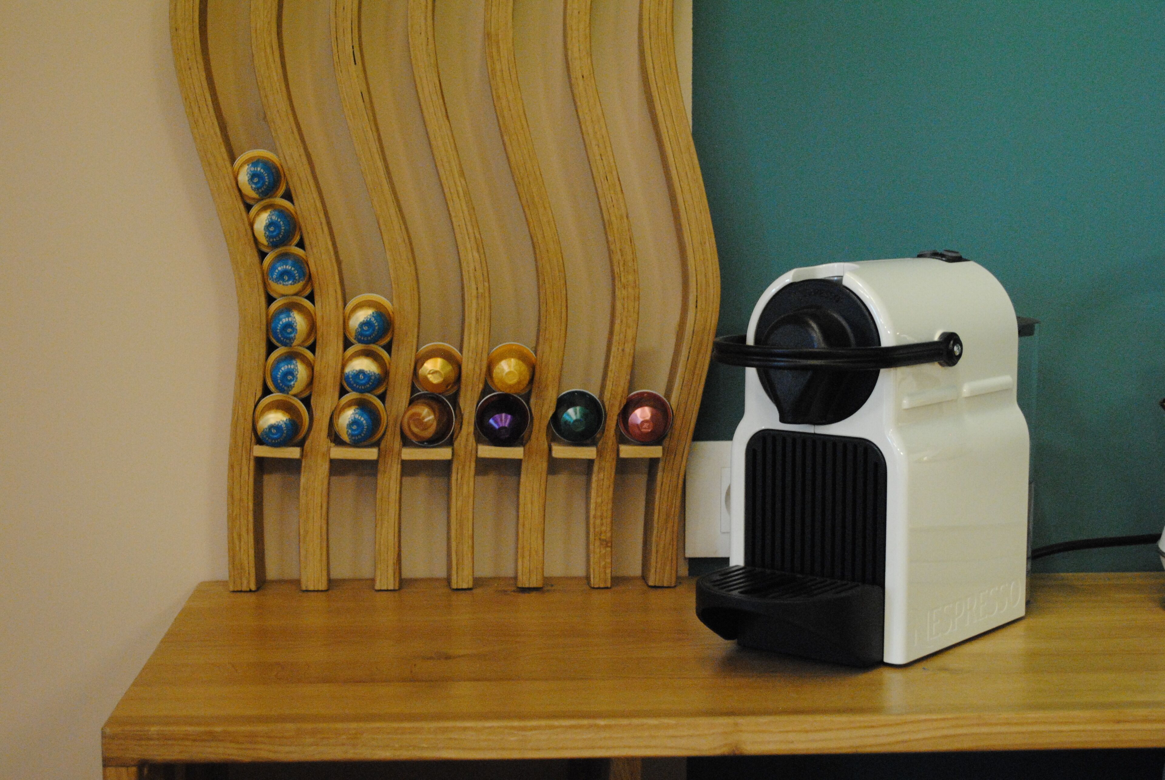 A coffee machine with a wooden stand holding various coffee pods.