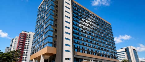 A modern multi-story hotel with a prominent entrance, large windows, and a flat roof.