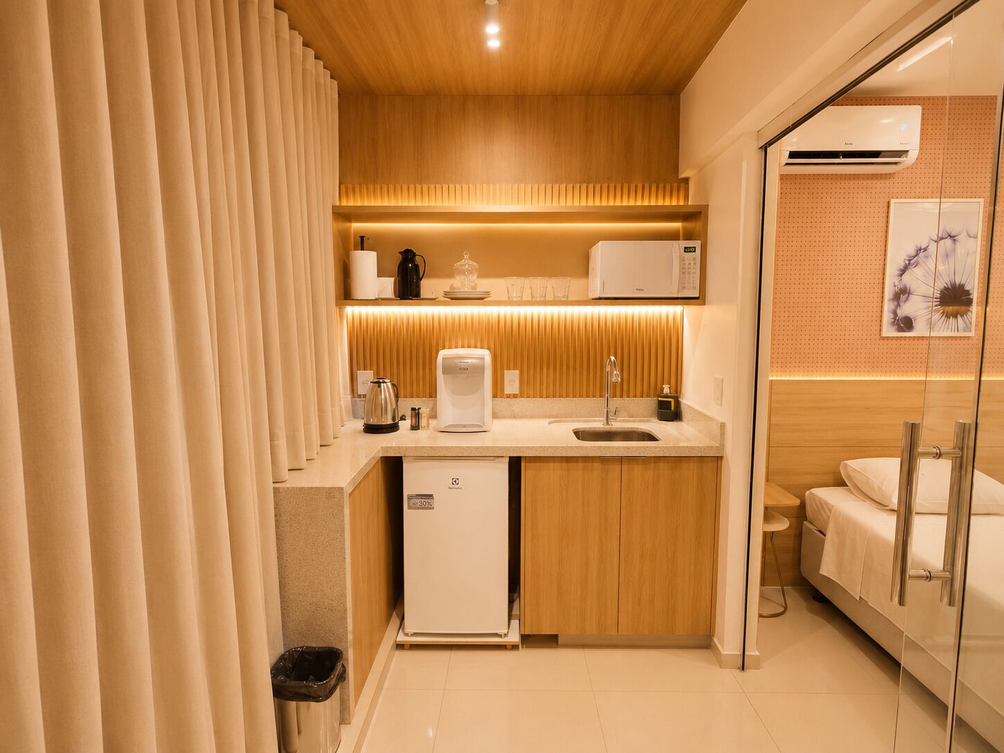A compact kitchenette with a coffee maker, microwave, and sink.