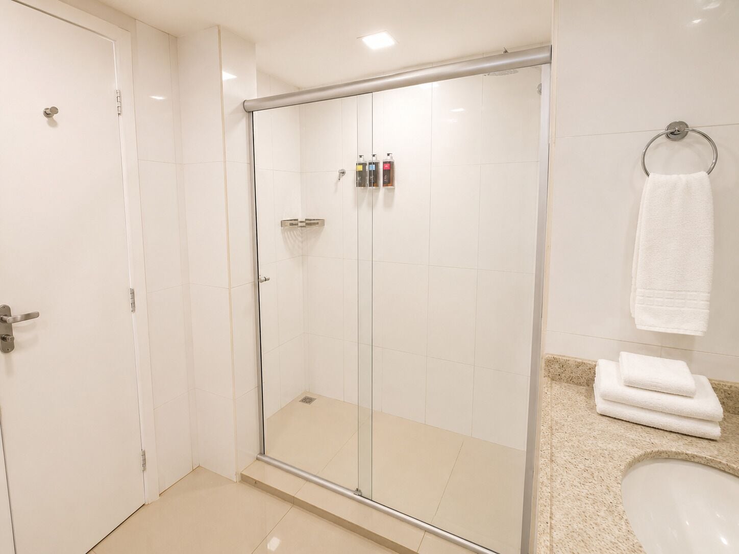 Un baño moderno con ducha de vidrio, inodoro y lavamanos.