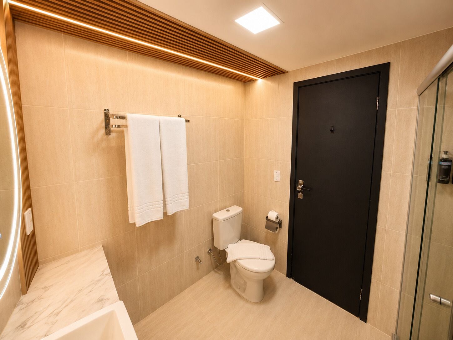 A modern bathroom with a toilet, bidet, and a bathtub.