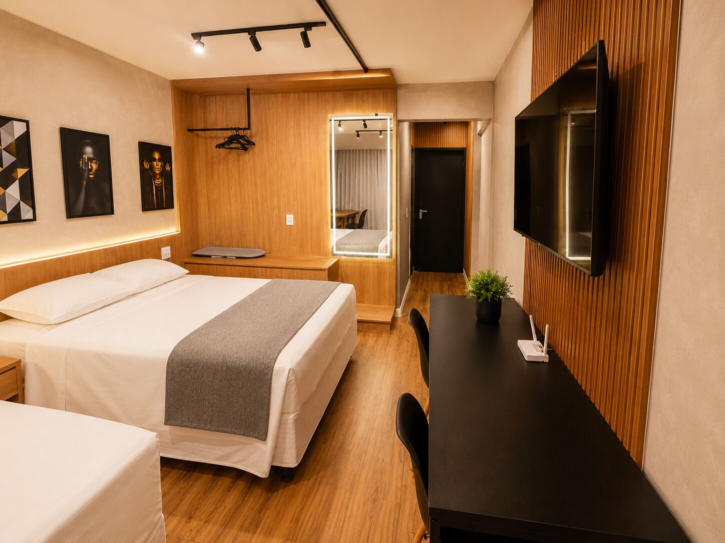 Une chambre d’hôtel moderne équipée d’un lit, d’une table de chevet, d’un bureau et d’un téléviseur.