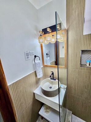 A modern bathroom with a round sink, a mirror, and a towel rack. - Boho-Chic Loft with Sea Views in Montego Bay (St.Bran's Burg)