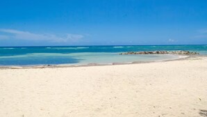A beach with clear turquoise water and a sandy shore.