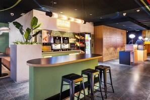 A modern bar area with stools, a counter, and a neon sign. - B&B Hotel Castellón (Castelló de la Plana)