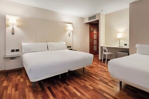 A hotel room with two beds, a desk, a chair, and two wall-mounted lamps. - B&B Hotel Castellón (Castelló de la Plana)