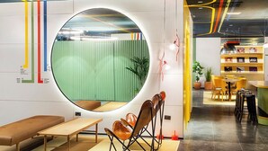 A modern interior with a circular window, seating area, and a bookshelf. - B&B Hotel Castellón (Castelló de la Plana)