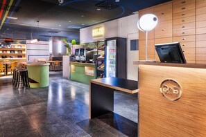 A modern hotel lobby with a reception desk, seating area, and a bar. - B&B Hotel Castellón (Castelló de la Plana)