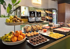 A buffet with various food items, including fruits, pastries, and a coffee station. - B&B Hotel Castellón (Castelló de la Plana)
