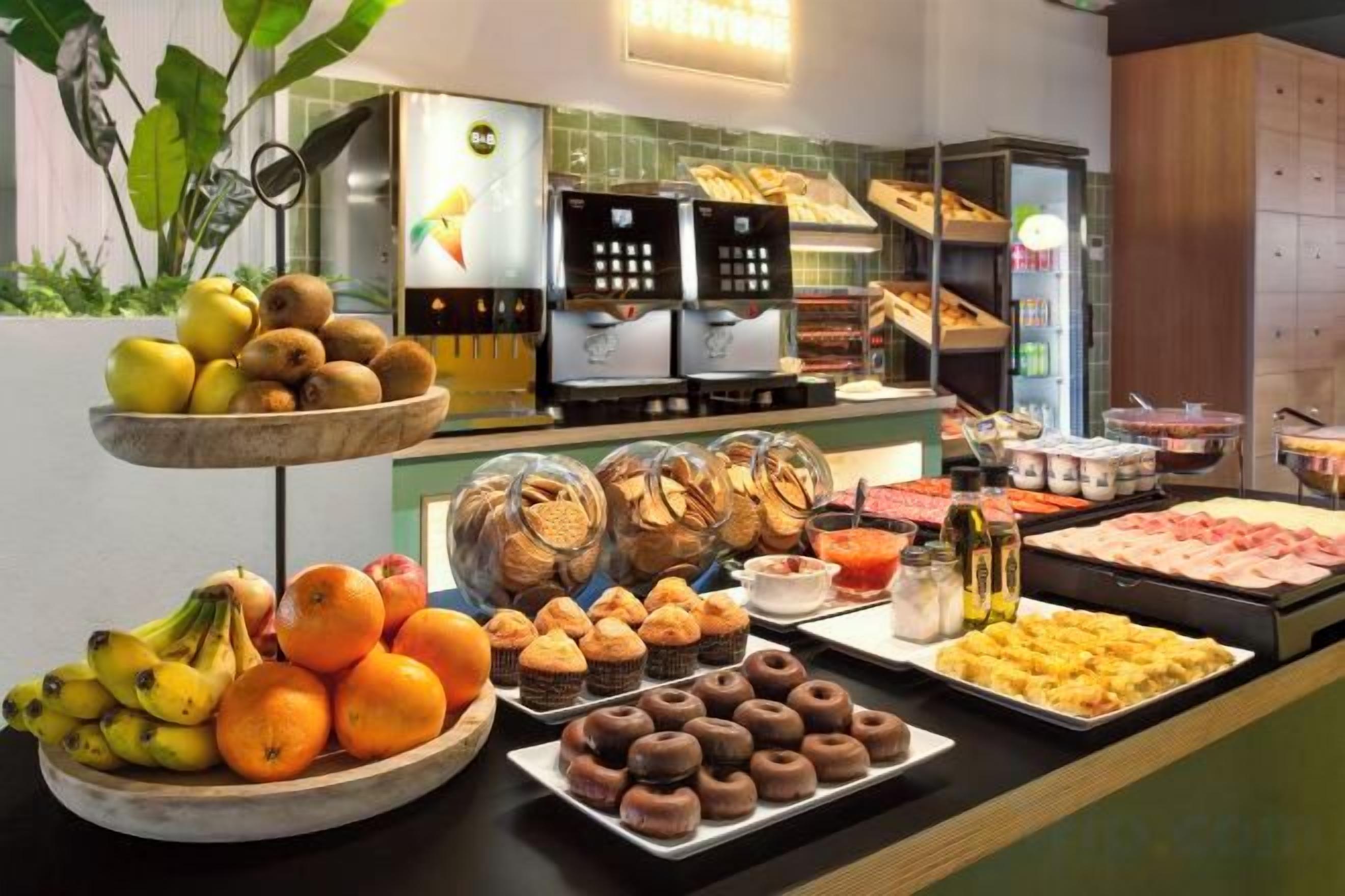 A buffet with various food items including fruits, pastries, and desserts.