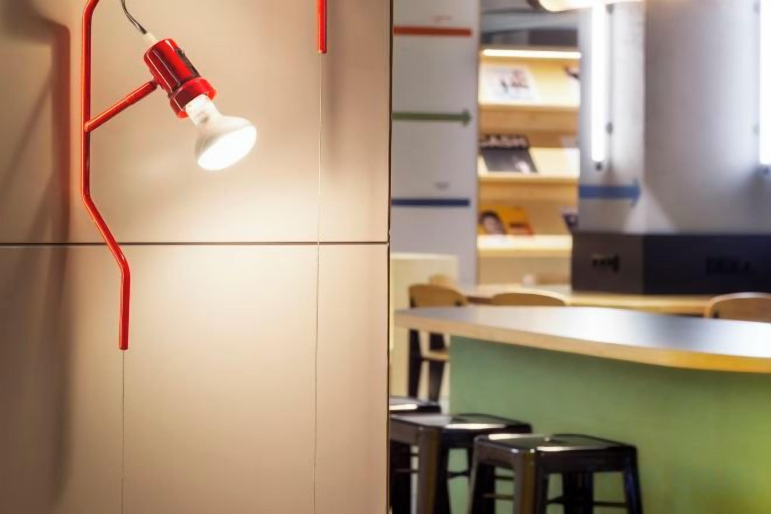 A room with a desk, chairs, and a red lamp.
