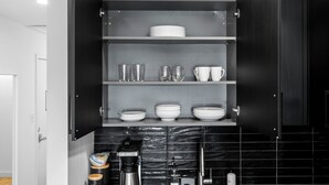 A kitchen with open cabinets displaying various dishes and glassware. - King Bed, Gym, 2min walk to UAB, Foodie Haven (Birmingham)
