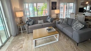 Ein modernes Wohnzimmer mit einem grauen Sofa, einem Holztisch und zwei Lampen.