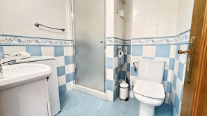 Een badkamer met wastafel, toilet en douchehoek.