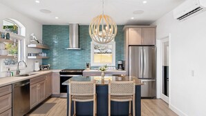 A modern kitchen with a central island, stainless steel appliances, and a blue backsplash. - Generator! 2 Primary Bedrooms - Magens Bay - Dining (St. Thomas)