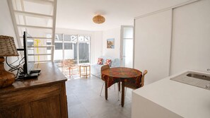 Eine moderne Küche mit Essbereich, einem großen Fenster und Blick ins Freie.
