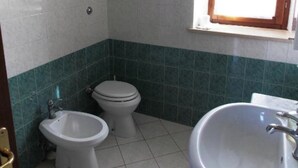 Un baño con inodoro, bidé y lavamanos.
