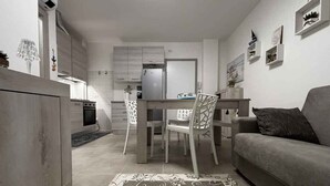 Un espace de vie compact comprenant une kitchenette, un coin repas et un canapé.