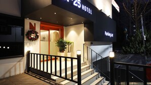 Entrada d'hotel amb un rètol que diu "No.25 Hotel" i un cartell de "Parking Lot".