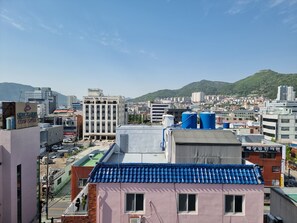 Un paisaje urbano donde destaca un hotel con techo de azulejos azules y un edificio rosa al frente.