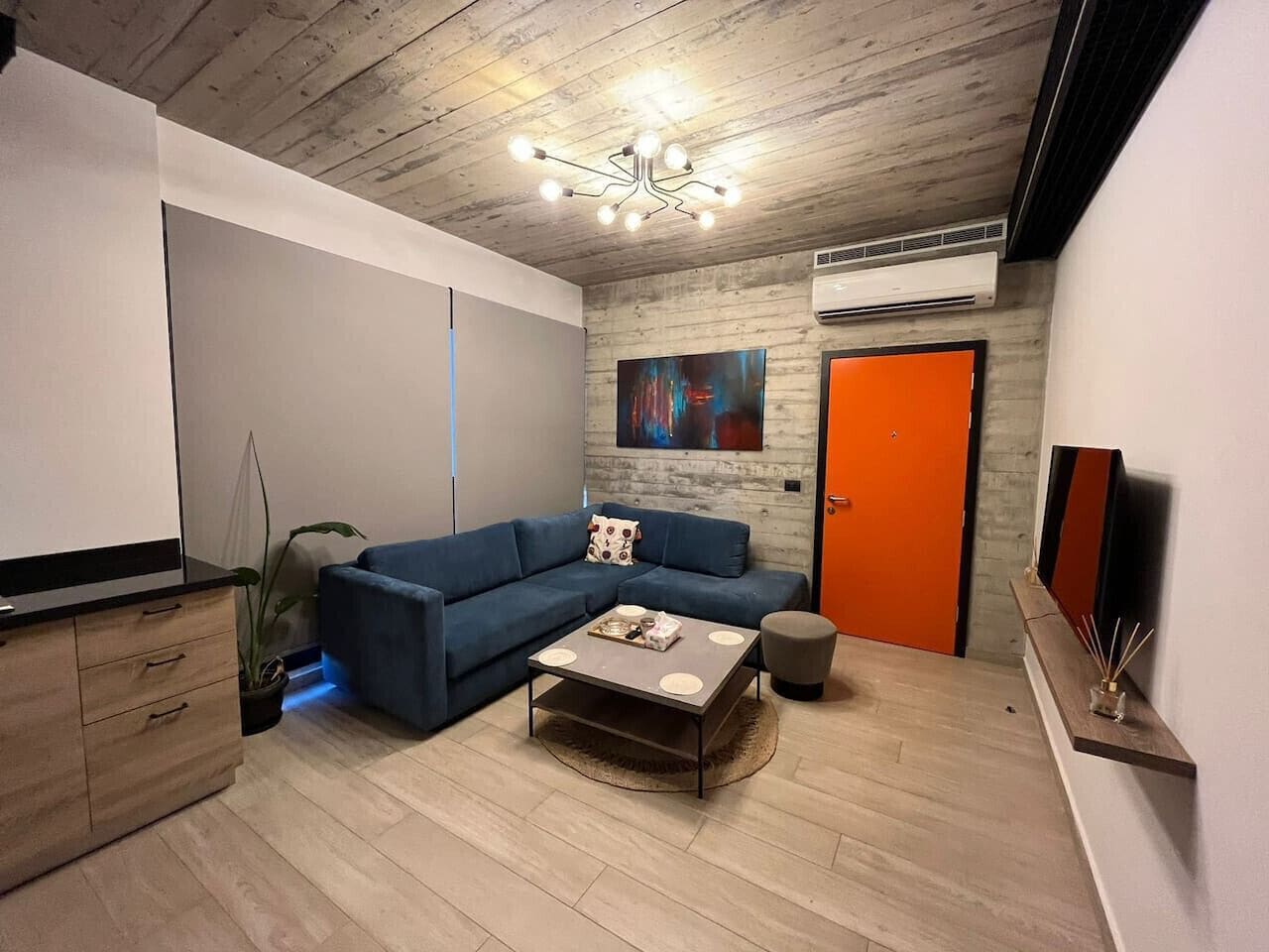 A modern living room with a sectional sofa, a coffee table, and a TV stand.