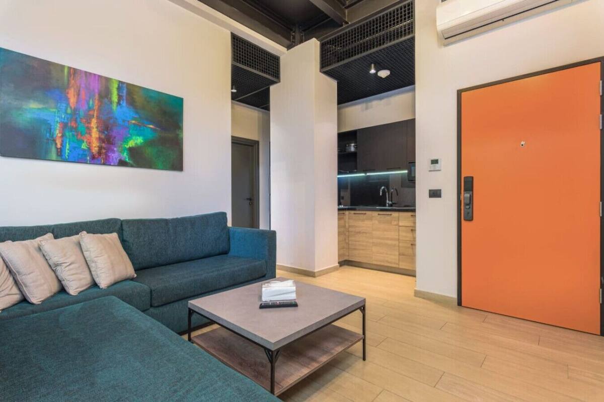 Un salón moderno con un sofá, una mesa de centro y un cuadro en la pared.