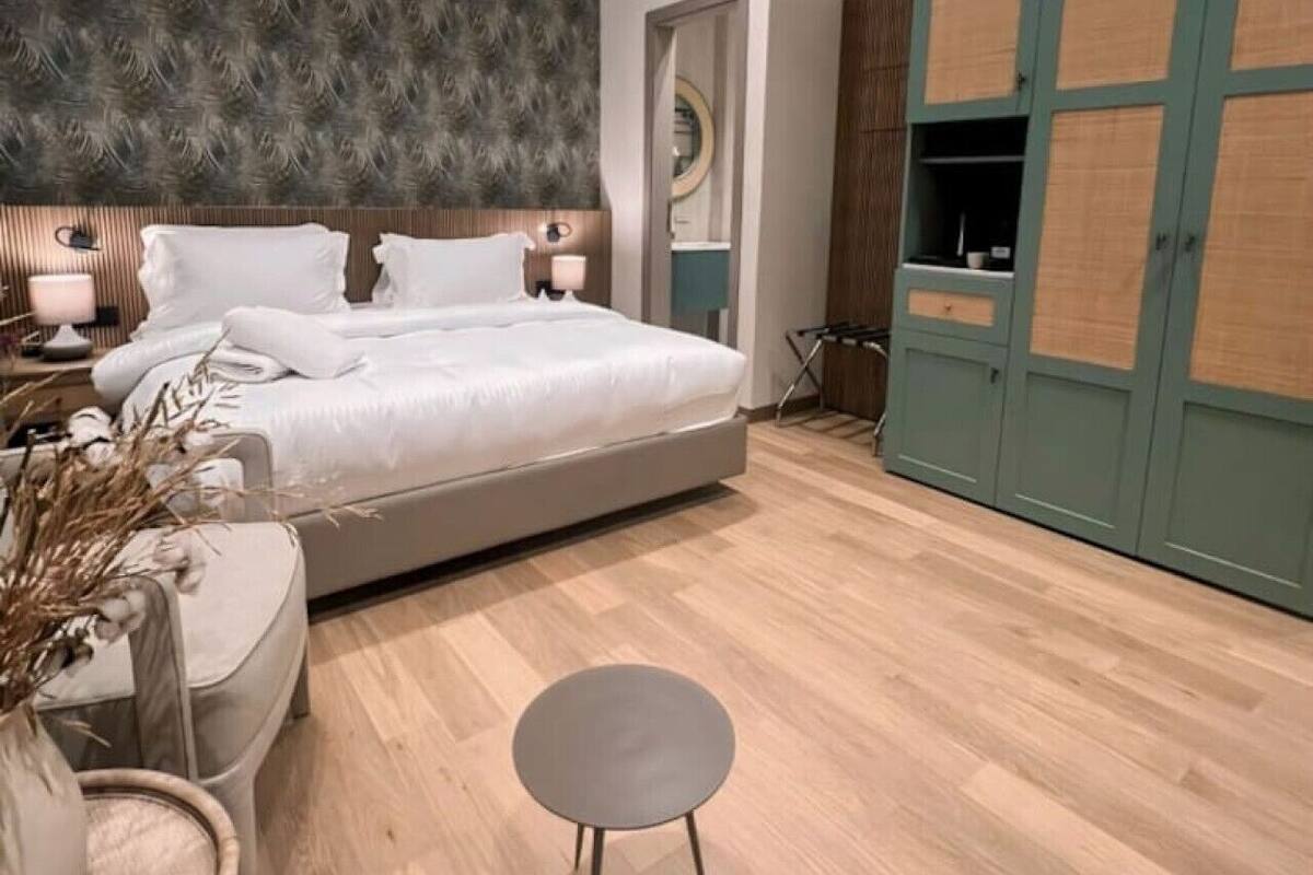 Un dormitorio moderno con una cama grande, una mesita de noche, una pequeña mesa redonda y un armario con diseño original.