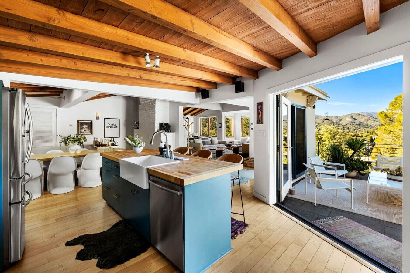 Stylish kitchen featuring a sleek center island, elegant wooden ceiling, and additional countertop seating—perfect for dining and entertaining.