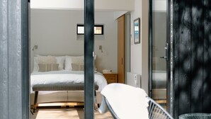 A bedroom with a bed, bedside table, and a chair. - Stables Cottage, Nethybeodge (Nethybridge)