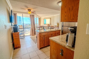 A kitchen with wooden cabinets, a granite countertop, and a ceiling fan.